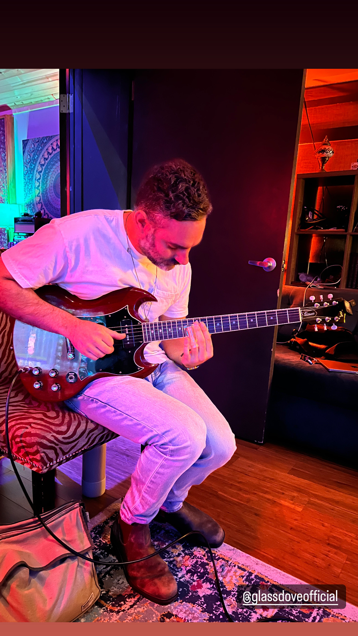Josh Benus playing guitar during a studio session